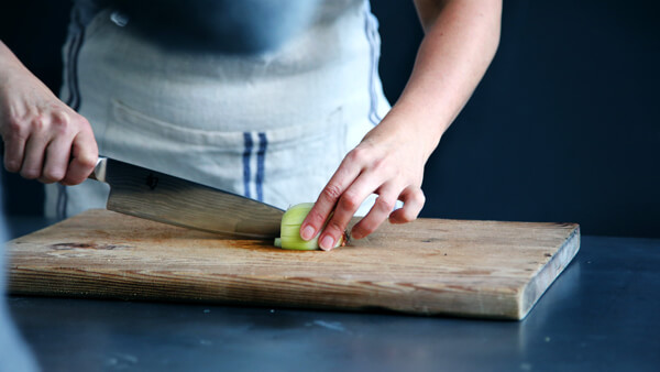 chopping onion on wooden cutting board